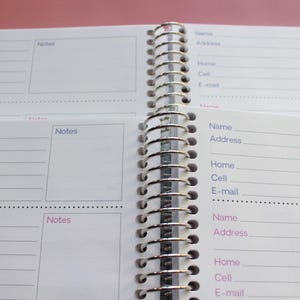 an open spiral-bound notebook with two pages visible, one of which has a blank space for notes and the other for contact information.