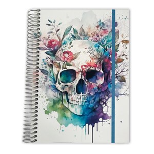 May include: A spiral-bound notebook featuring a watercolor illustration of a human skull surrounded by colorful flowers and foliage. The design includes vibrant splashes of blue, purple, green, and red paint, with a vertical blue elastic band closure.