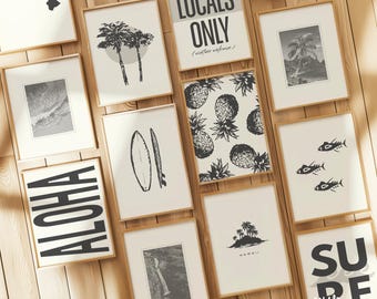 May include: A collection of framed art prints with a tropical theme. The prints feature images of palm trees, pineapples, surfboards, fish, and the text "Aloha", "Locals Only", "Surf", and "Hawaii". The frames are a light brown color.