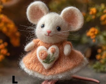 Puede incluir: Una figura de ratón de fieltro hecha a mano con cuerpo blanco, grandes orejas rosas y nariz rosa. Viste un vestido naranja con una aplicación en forma de corazón. El ratón tiene ojos negros y largos bigotes. La letra "L" está en la esquina inferior izquierda.