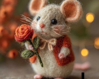 Puede incluir: Una figura de ratón de fieltro hecha a mano sosteniendo una rosa roja. El ratón lleva una pequeña chaqueta naranja y tiene detalles rosas en sus patas y orejas. El fondo está borroso con tonos cálidos.