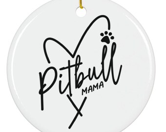 May include: A white ceramic ornament with a gold string for hanging. The ornament features the words "Pitbull Mama" in black script, with a heart and paw print design.