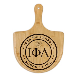 Op de afbeelding: Een bamboe snijplank met een handvat en een cirkelvormig embleem. Het embleem toont de woorden "IOTA PHI LAMBDA SORORITY INC." rond een roos en de Griekse letters "ΙΦΛ".