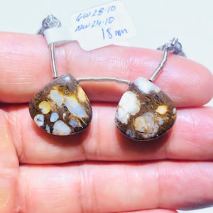 May include: Two brown and white teardrop-shaped stones with a silver chain. The stones are approximately 18 mm in size. The label reads "GW 28-10 New 24.1D 18 mm".