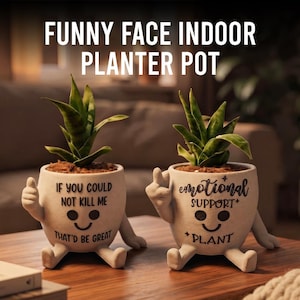 May include: Two off-white ceramic planters with arms and legs, each holding a green plant. The left planter features a thumbs-up gesture and text reading IF YOU COULD NOT KILL ME THAT'D BE GREAT. The right planter shows a middle finger and text reading emotional SUPPORT PLANT.