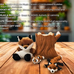 A charming display featuring a plush fox, two articulated fox figurines, and a detailed tree stump container. The plush fox sits upright, while the two articulated foxes rest playfully near the base of the stump. Text on the left highlights product features like the "Full Trash Squad," "Fidget-Ready Fun," and "Perfect Gift Vibe." The setup is staged on a rustic wooden table with a blurred, cozy indoor background, emphasizing a warm and whimsical atmosphere.
