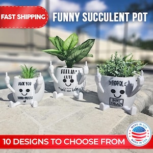 May include: Three white ceramic succulent pots with funny faces and sayings. The pots have arms and legs and are holding up their middle fingers. The sayings on the pots are "Aloe You Very Much", "Feelin' Cute Might Die Later", and "Totale Pot Head".