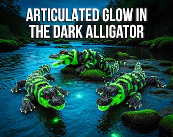May include: Three articulated alligator toys with a glow-in-the-dark green and black design are displayed in a river setting. The text "ARTICULATED GLOW IN THE DARK ALLIGATOR" is at the top of the image. The alligators are on rocks and in the water.
