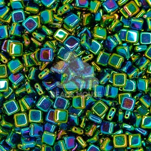 May include: A close-up of a pile of iridescent green and blue square glass beads. The beads have a metallic sheen and are perfect for jewelry making.