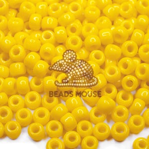 May include: A close-up of many bright yellow beads. The beads are cylindrical with a hole through the middle. A logo of a mouse made of small beads is in the centre, with the text "BEADS MOUSE" below it.