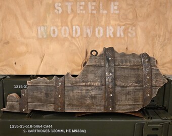 May include: A wooden cutout of the state of Virginia, painted in a dark brown color, with metal bands and rivets. The cutout is mounted on a wooden background with the text "STEELE WOODWORKS" and other information about the product.