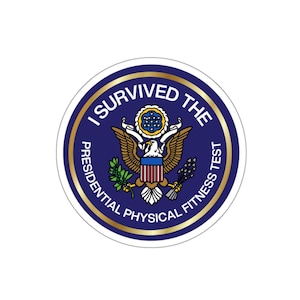 Op de afbeelding: Een ronde sticker in blauw en goud met de tekst "I Survived The Presidential Physical Fitness Test" en een zegel met een adelaar en de Amerikaanse vlag.