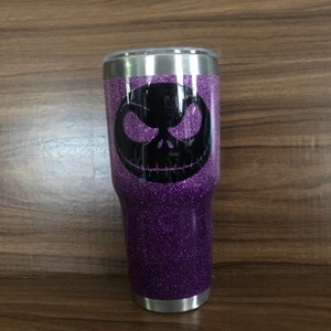 May include: Purple glitter tumbler with a black Jack Skellington face design.