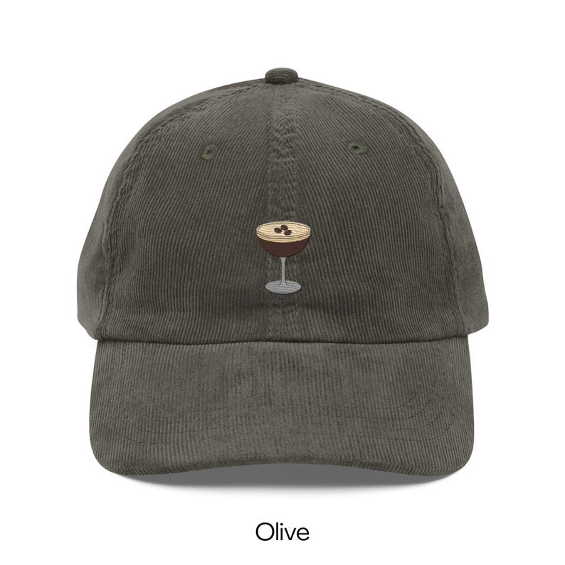 May include: Olive green corduroy baseball cap featuring an embroidered cocktail glass with three coffee beans. The cap has a curved brim and a top button. The word "Olive" is printed at the bottom of the image.