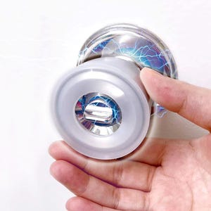 May include: A silver door knob with a clear plastic cover featuring a blue and white lightning bolt design.