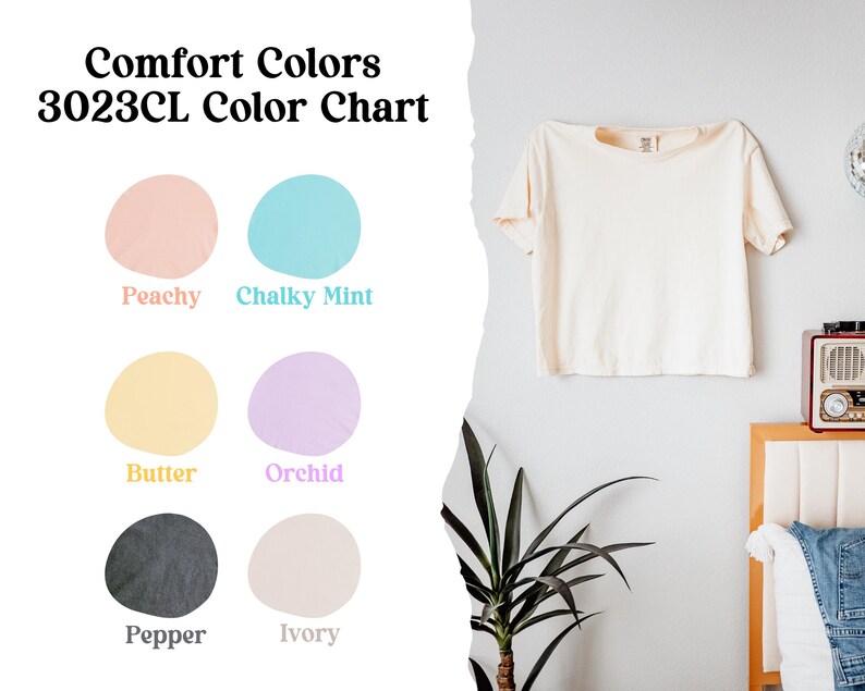 May include: Comfort Colors 3023CL color chart featuring a short-sleeve t-shirt in ivory. The chart displays six circular color swatches labeled Peachy, Chalky Mint, Butter, Orchid, Pepper, and Ivory, showcasing the available fabric color options.