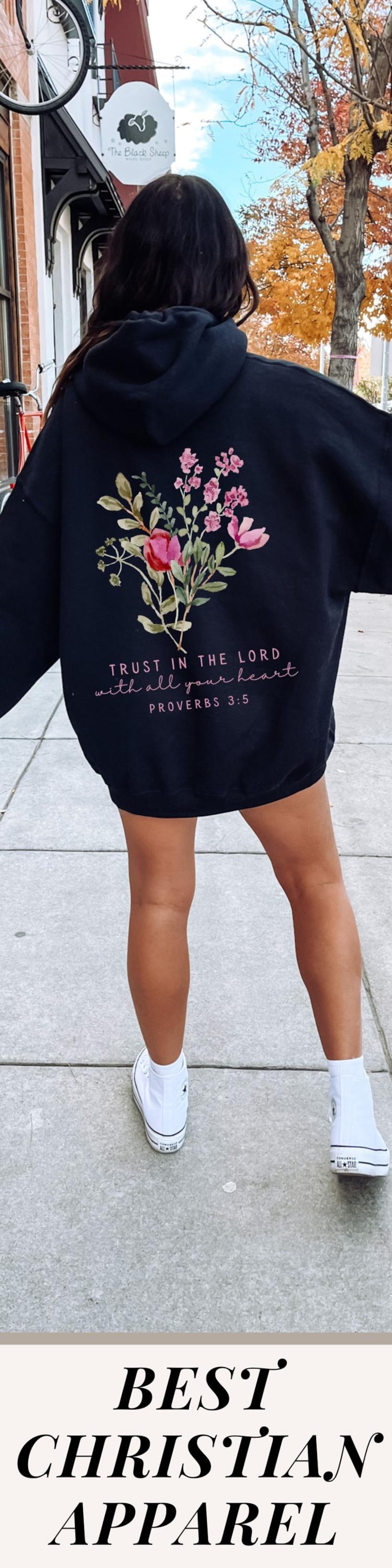 May include: Black hoodie with a floral design and the text "TRUST IN THE LORD with all your heart PROVERBS 3:5". The image also includes the text "BEST CHRISTIAN APPAREL". The hoodie is paired with white high-top sneakers.