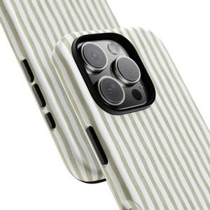 May include: Close-up of two phone cases. The cases have a vertical striped pattern in light green and white. The phone case in the foreground has a black camera lens protector. The phone cases are angled towards the viewer.