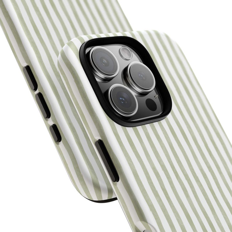 May include: Close-up of two phone cases. The cases have a vertical striped pattern in light green and white. The phone case in the foreground has a black camera lens protector. The phone cases are angled towards the viewer.