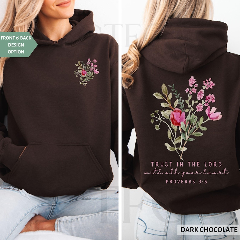 May include: Dark chocolate hoodie with a floral design on the front and back. The front features a small bouquet, while the back displays a larger arrangement with the text "TRUST IN THE LORD with all your heart PROVERBS 3:5".