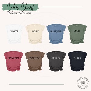 May include: A color chart displaying eight Comfort Colors 1717 t-shirts in various hues. Colors include white, ivory, blue jean, moss, crimson, espresso, pepper, and black. The text "Color Chart" and "Comfort Colors 1717" are at the top.