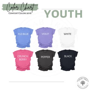 May include: A color chart of youth t-shirts in various colors, including Flo Blue, Violet, White, Crunch Berry, Pepper, and Black. The text "Color Chart" and "Comfort Colors 9018" are at the top. The word "YOUTH" is also displayed.