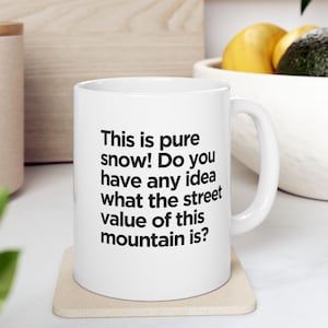May include: White ceramic mug with a black text saying "This is pure snow! Do you have any idea what the street value of this mountain is?"