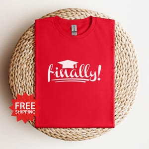 May include: Red t-shirt with a white graduation cap and the text "finally!" printed on the front.