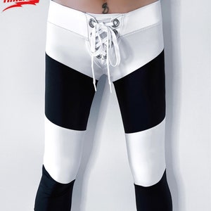May include: Black and white striped leggings with a white waistband and a lace-up detail in the front.