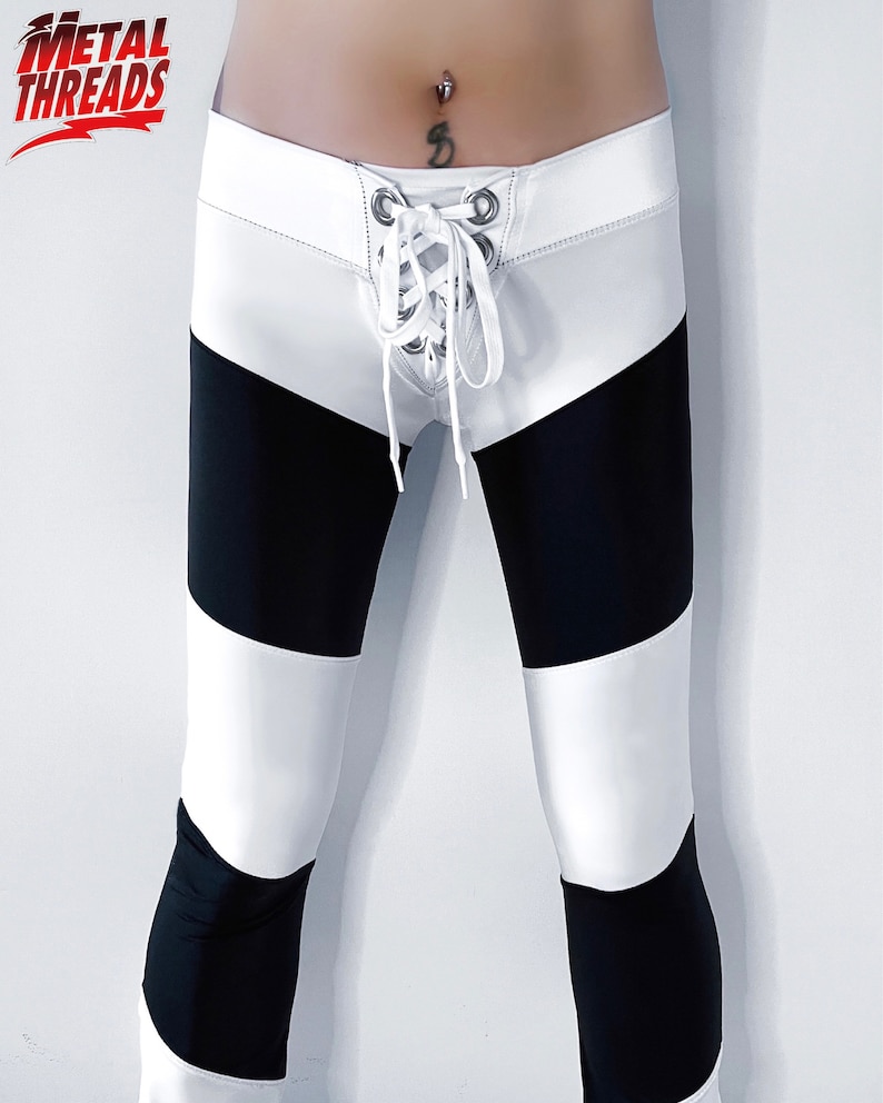 May include: Black and white striped leggings with a white waistband and a lace-up detail in the front.