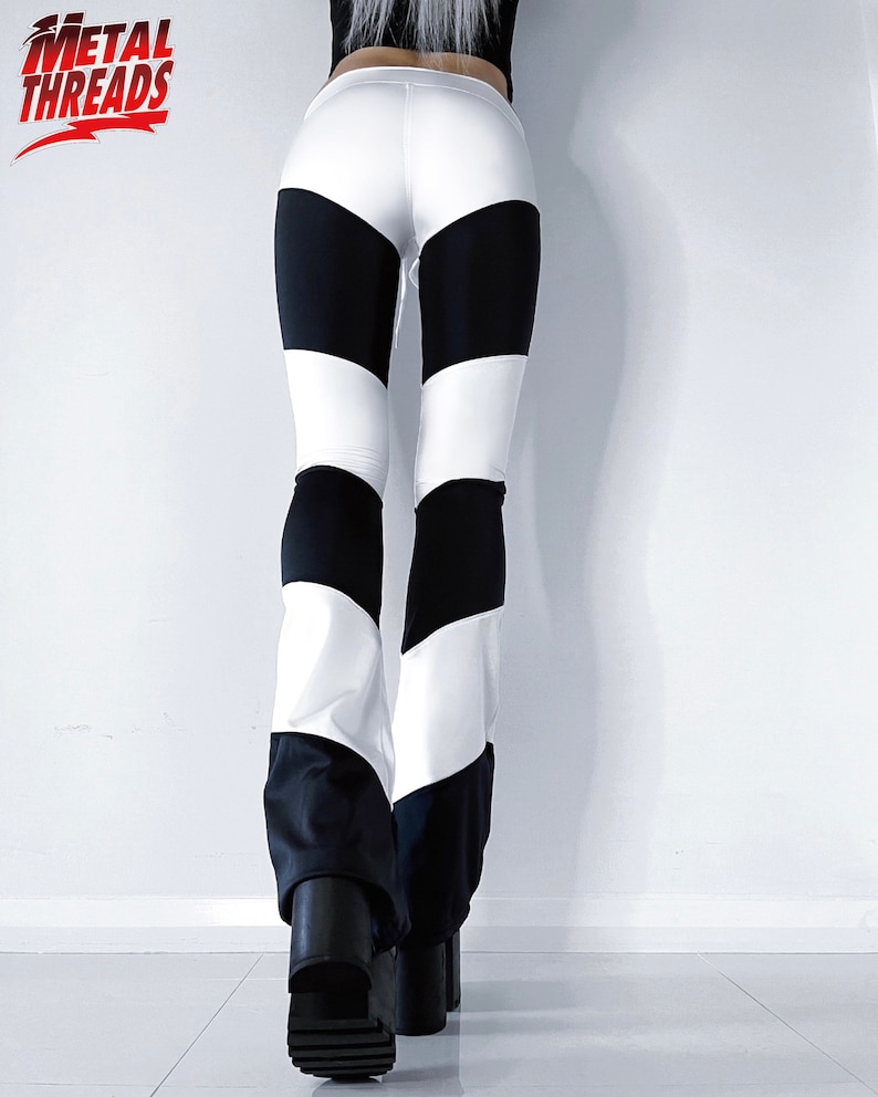 May include: Black and white striped leggings with a flared leg style. The leggings are made of a stretchy, comfortable material.