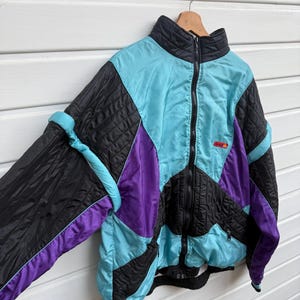 May include: A white ceramic mug with a black handle and the text "But First, Coffee" in a black, handwritten-style font. The mug is on a white surface.