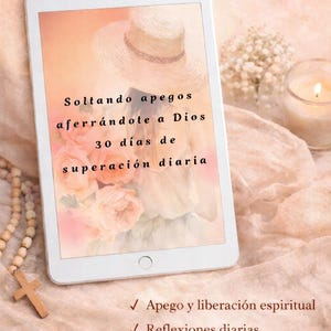 Puede incluir: Una tableta digital muestra texto en español: "Nuevo Devocional Católico" y "Soltando apegos aferrándote a Dios". La pantalla muestra un sombrero, flores y texto sobre crecimiento espiritual. Texto adicional incluye "Tiempo ilimitado".