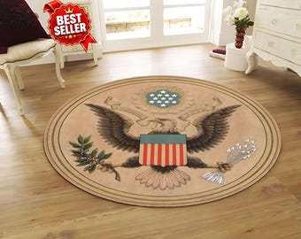 May include: A round area rug featuring a vintage-style illustration of the Great Seal of the United States. The design includes a bald eagle with outstretched wings, a shield with red and white stripes, an olive branch, and a bundle of arrows.