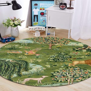 May include: Round green rug with a detailed illustration of a garden scene. The rug features trees, flowers, a lion, a dog, and birds. The rug is placed on a wooden floor.