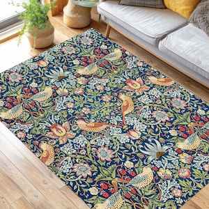 Op de afbeelding: Een blauw tapijt met een bloemenpatroon en vogels. Het tapijt heeft een donkerblauwe achtergrond met groene, gele en rode bloemen en vogels.