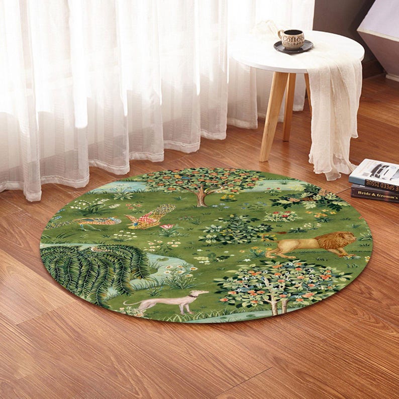 May include: Round green rug with a detailed illustration of a garden scene. The rug features a lion, a dog, and a peacock. The rug is placed on a wooden floor near a white table and a window.