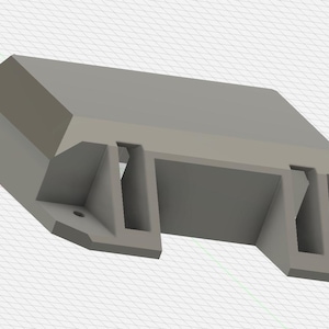 Peut inclure: Une pièce en plastique gris imprimée en 3D avec deux fentes ouvertes et une section rectangulaire surélevée sur le dessus.