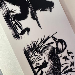 May include: Black and white illustration featuring a duck hunter with a dog, a duck, and a bigfoot-like creature with a rifle. The hunter is aiming at a duck in a marshy area. The bigfoot-like creature is also aiming a rifle.