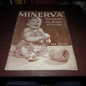 May include: A vintage Minerva magazine cover featuring a baby wrapped in yarn, with the title "Minerva Garments for Babies and Juveniles" and the volume number "Vol. 31-15¢".