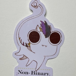 May include: A white sticker featuring a cartoon character with large brown eyes and a small mouth. The character has purple and black hair and is wearing sunglasses. The sticker has the text "Non-Binary" and the username "@ScreamingLemon947".