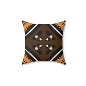 May include: A brown, black, and orange patterned throw pillow with a geometric design.