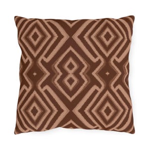 May include: Square throw pillow with a geometric pattern in shades of brown. The design features repeating diamond shapes and lines, creating a symmetrical and textured appearance. The pillow is likely made of a soft fabric, suitable for home decor.
