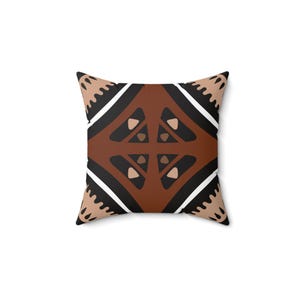 May include: A square throw pillow with a geometric pattern in shades of brown, black, and white. The pattern features a central diamond shape with smaller triangles and diamonds within it.