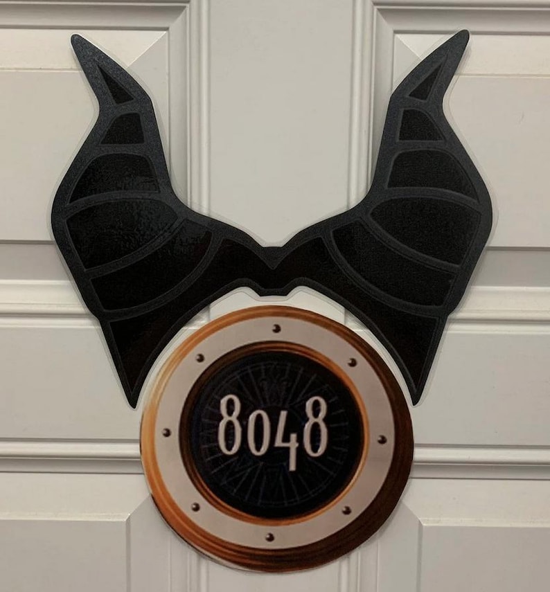 May include: Black and gold door hanger with a pair of black horns and a round gold circle with the number 8048 in the center.