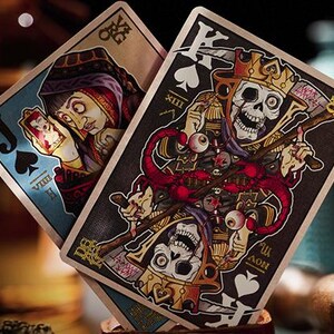 May include: Two playing cards, a Jack of Spades and a King of Spades, from a deck of playing cards with a dark, gothic, and macabre design. The Jack of Spades features a blue background with a woman in a blue and red dress holding a smaller card. The King of Spades features a black background with a skeletal figure wearing a crown and holding a scythe.