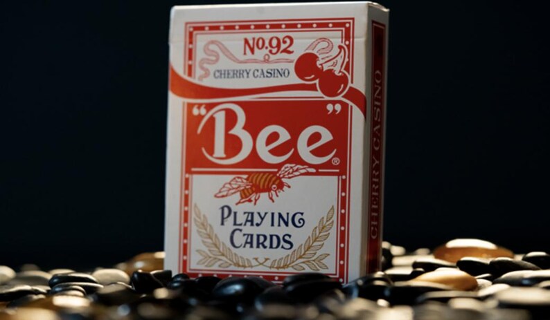 May include: A red and white deck of Bee playing cards with a bee illustration and the text "No. 92 Cherry Casino" and "Bee Playing Cards".