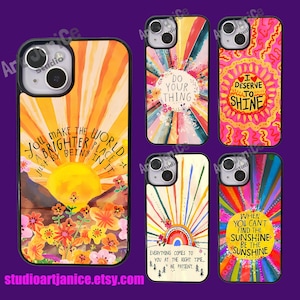 Puede incluir: Conjunto de cuatro fundas de teléfono coloridas con citas inspiradoras. Las fundas presentan una salida del sol, un arcoíris y rayos de sol. Las citas son "You make the world a brighter place just by being in it", "Do your thing", "I deserve to shine", and "When you can't find the sunshine, be the sunshine".
