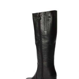 May include: Black leather knee-high boots with a block heel and a zipper up the back.