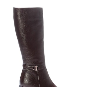 May include: A knee-high, dark brown leather boot with a textured finish. The boot features a small strap with a silver buckle around the ankle and a block heel. The heel measures approximately 5 cm.